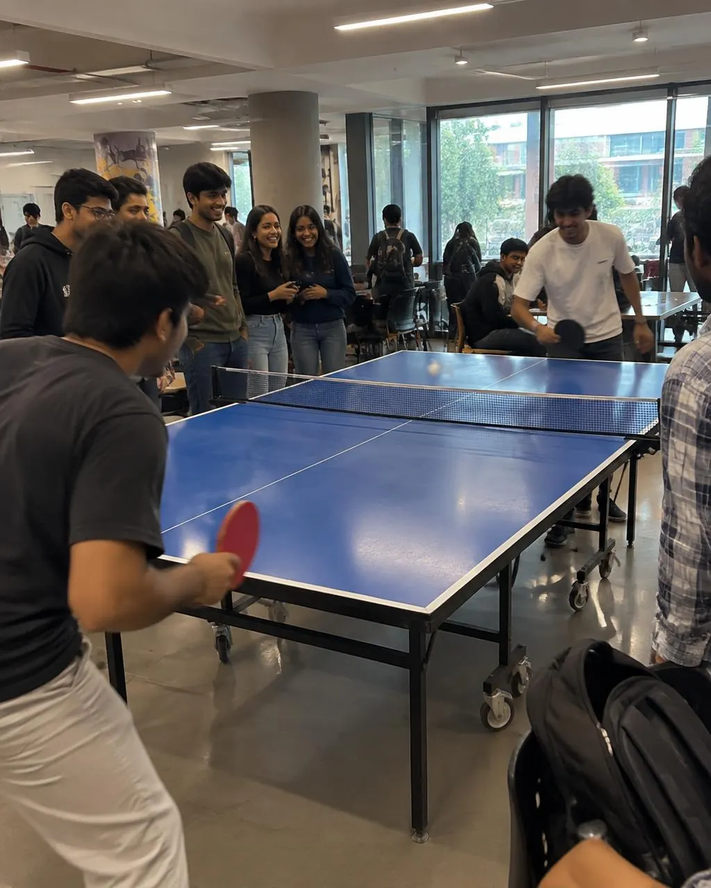 Illustrative student table tennis gathering in a campus common area